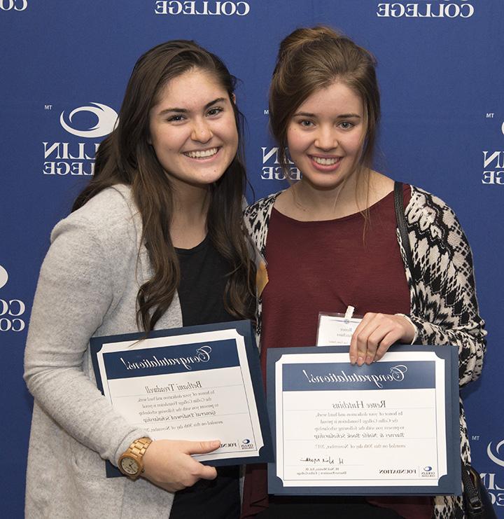Two girls holding certificates